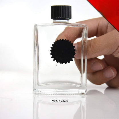 Venom symbiote ferrofluid kit in a clear glass bottle, held by a hand, with a black star-shaped label.