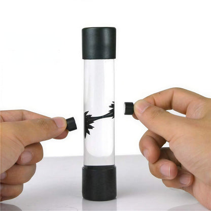 Venom symbiote ferrofluid kit with a clear tube and black ferrofluid forming shapes, held by two hands.