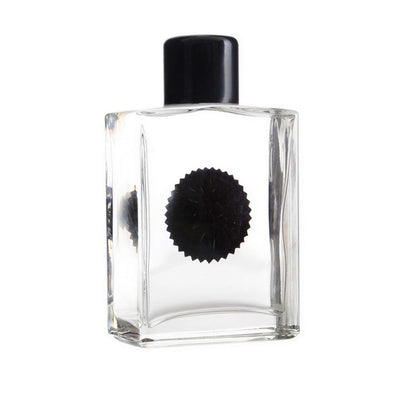 Venom symbiote ferrofluid kit in a clear glass bottle with a black cap and circular black design on the front.