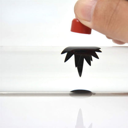 Venom Symbiote ferrofluid kit with a hand holding a red cap above the fluid, showcasing its unique black shape.